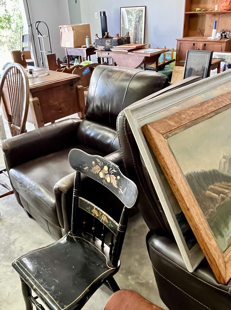 Windsor chairs, framed artwork and household furniture being sorted during a family move